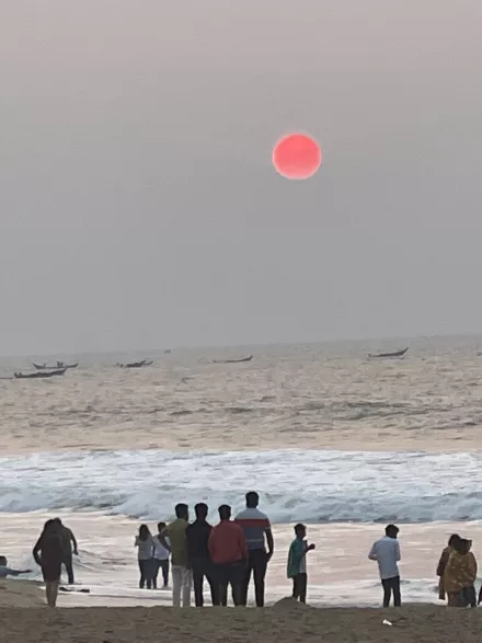 People standing on a beach watching the eclipse