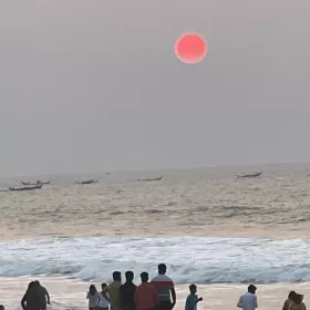 People standing on a beach watching the eclipse