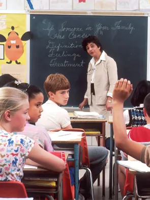 Learners sitting in a classroom engaging with a teacher