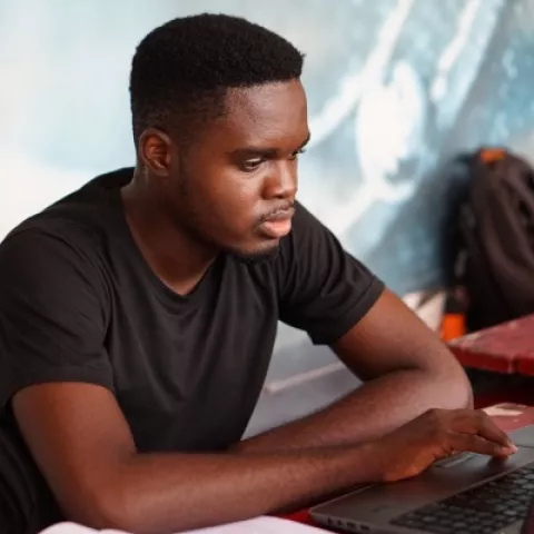 Student using a computer – courtesy of Kojo Kwarteng, Unsplash