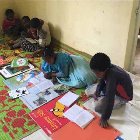 Children sitting on the floor and reading books