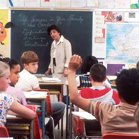 Learners sitting in a classroom engaging with a teacher